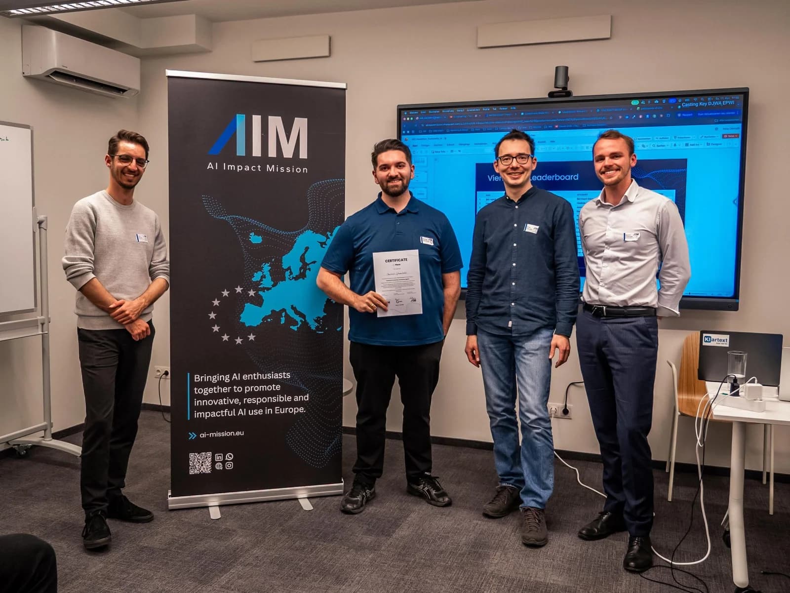 Bernhard Götzendorfer, Zweiter von links, mit der Urkunde des BitGN PAC Hackathon vor dem AI-Impact-Mission-Rollup.